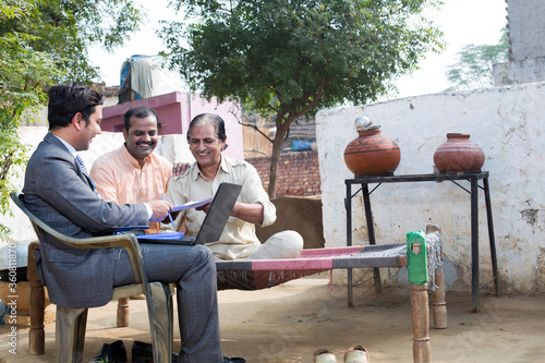 Photography Life insurance agent showing online policy on laptop.