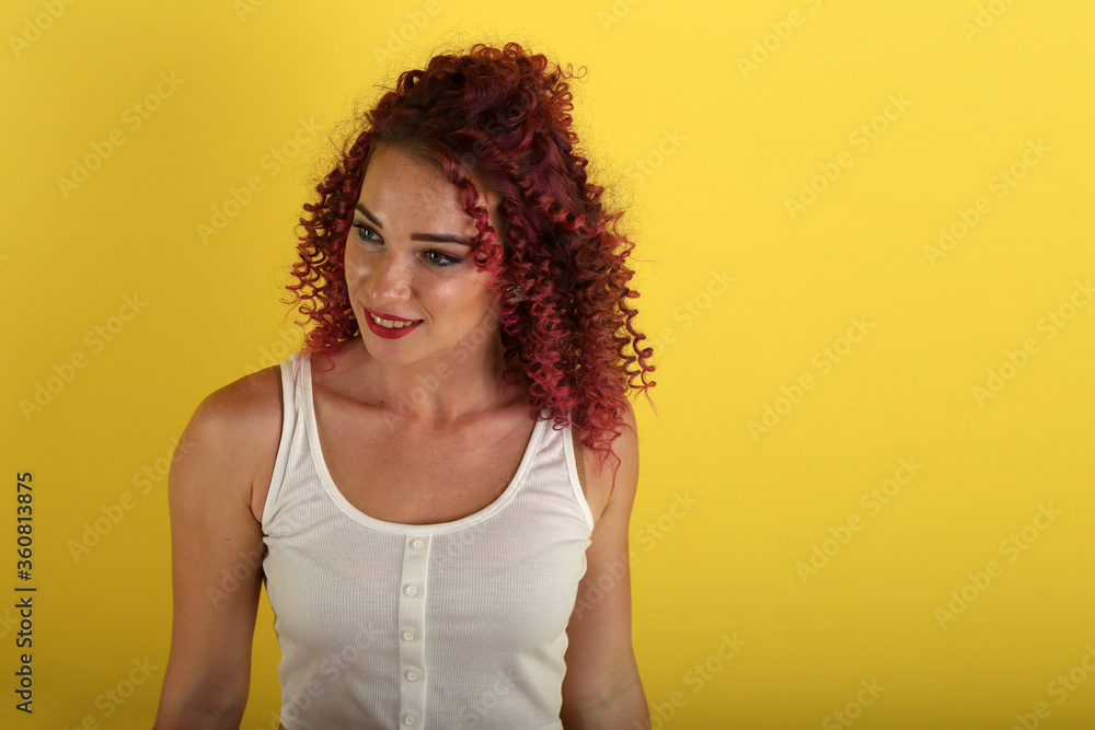 portrait of curly girl on a yellow background portrait of curly girl on a yellow background