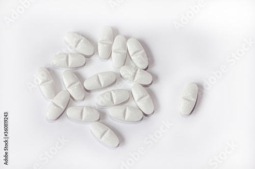 White pills on a white background close-up. Painkillers. A remedy for the Covid19 virus. Tablet macro. Copy space.