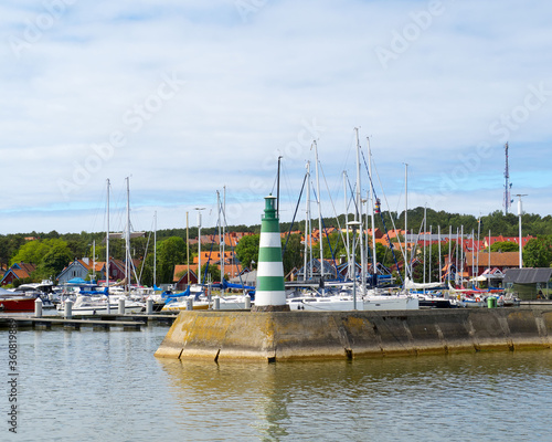 Entrance to the harbor with yachts. Lighthouse at the gates of the port. photo