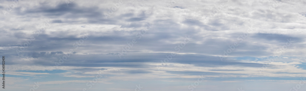 Panorama of blue sky with dense white and gray clouds
