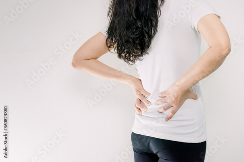 Hand holding the waist behind the low back pain