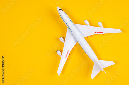 Airplane model. Large passenger plane top view. Two-story liner on a yellow background. Concept - travel by plane. Miniature airliner top view. Aeromodelling. Concept - Collecting Aircraft Models