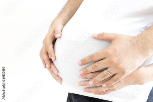 出産予定日の近い妊婦と夫がお腹を触る