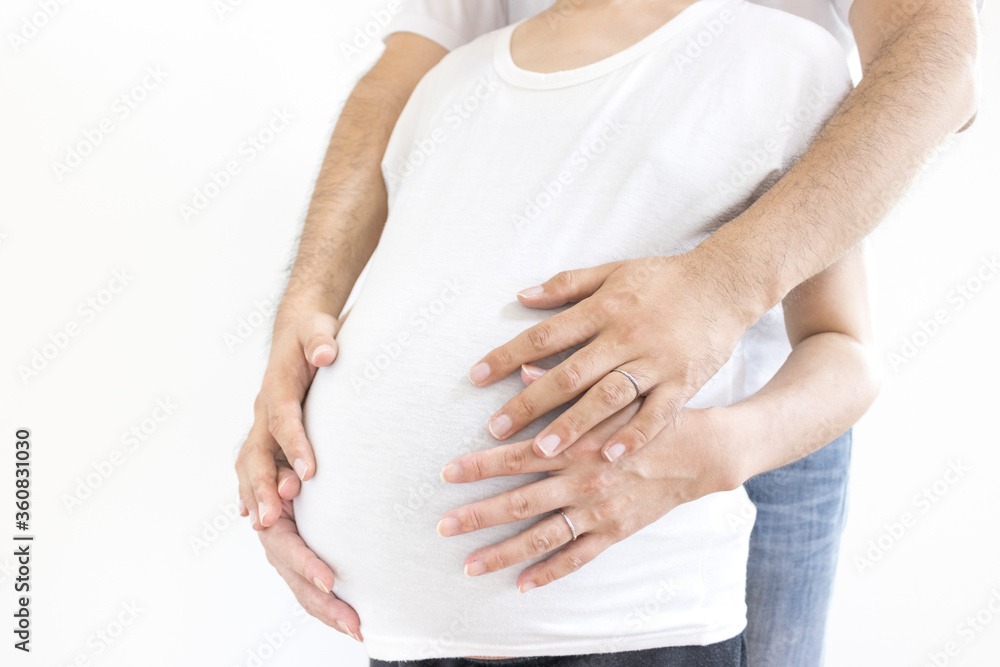 出産予定日の近い妊婦と夫がお腹を触る 出産予定日の近い妊婦と夫がお腹を触る