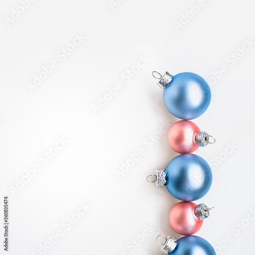 Blue and rose Christmas ornaments on white background with copy space