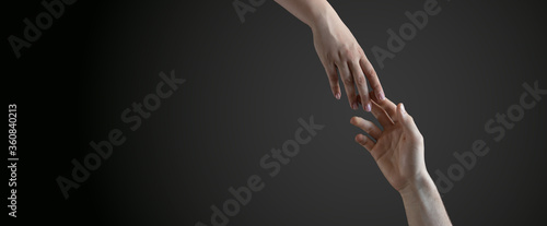 male and female hands reach towards each other