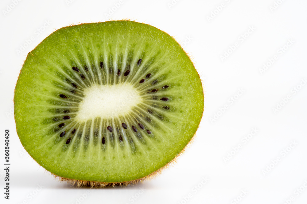 Slice of kiwi fruit cut to half isolated on white background with copy space Slice of kiwi fruit cut to half isolated on white background with copy space