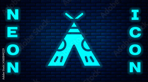 Glowing neon Traditional indian teepee or wigwam icon isolated on brick wall background. Indian tent.  Vector Illustration