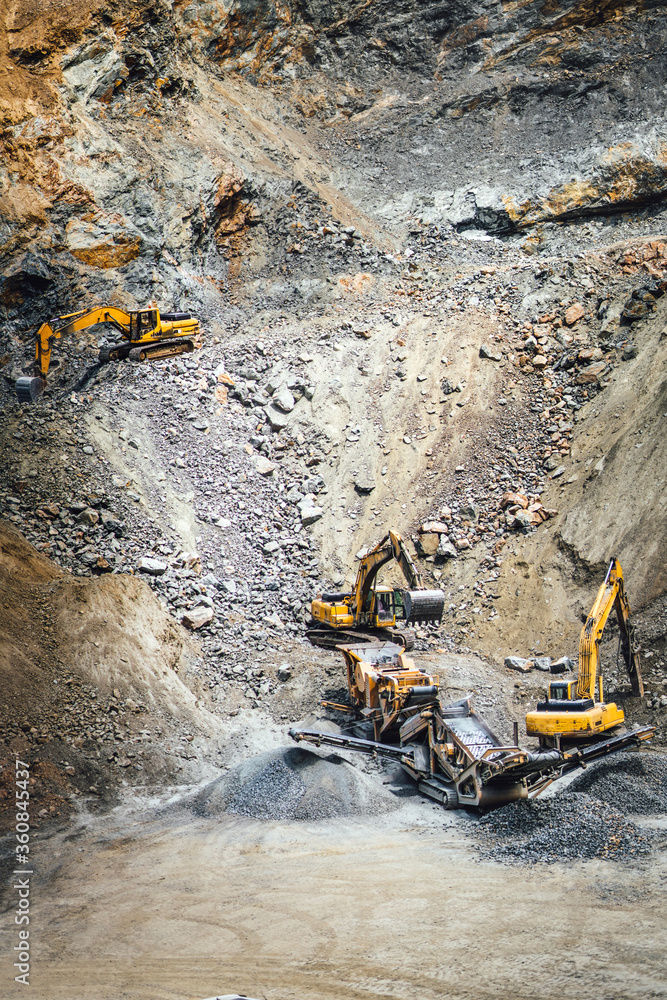 Industrial machinery and heavy duty excavators working at rock quarry. Industrial rock breaker working Industrial machinery and heavy duty excavators working at rock quarry. Industrial rock breaker working