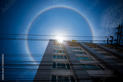 Amazing natural phenomena. Sun halo in Thailand or the sun with a rainbow on a tall building.