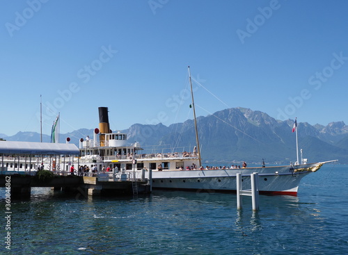 MONTREUX, SWITZERLAND on JULY 2017: Paddle-wheel steam boat moored ready to cruise at promenade on Geneva Lake in european city in canton Vaud, clear blue sky in warm sunny summer day.