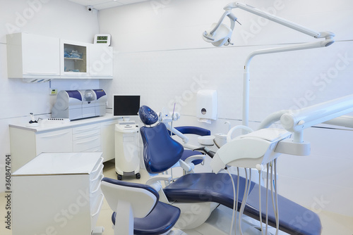 An interior of a dental office with white and blue furniture. Dentist’s office.