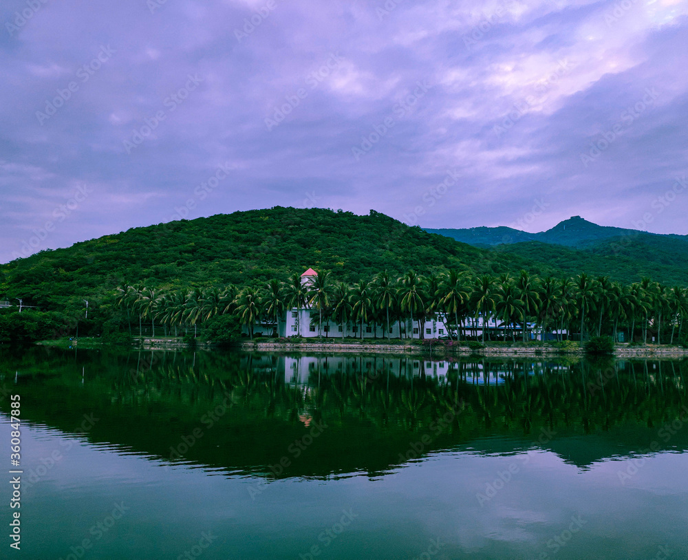 beautiful cloudy landscape with a lake that reflects palm trees and hills beautiful cloudy landscape with a lake that reflects palm trees and hills