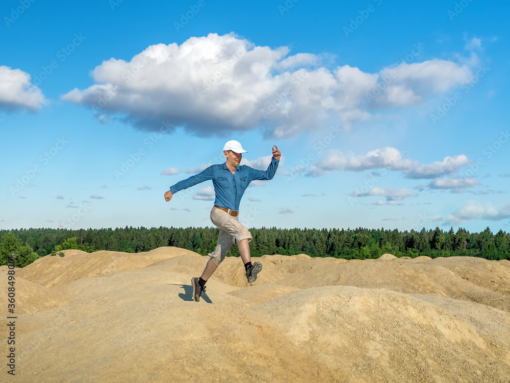 Plakat A cheerful man jumps on the hills