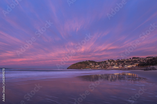 Beautiful sunrise of old jetty piles at St. Clair Beach in Dunedin, New Zealand.