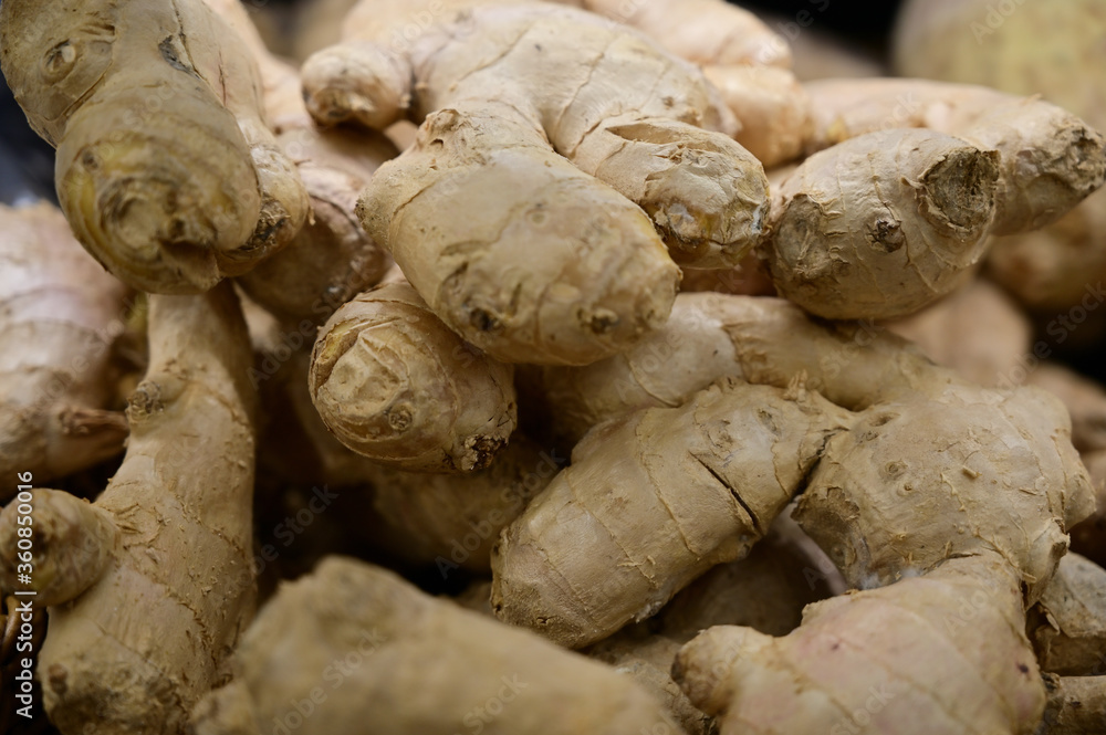 A large photo of ginger root fruits on a tray in a store, ready for sale A large photo of ginger root fruits on a tray in a store, ready for sale