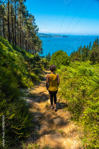 Valokuva A young brunette on the trail trekking down to the town of Orio, Guipuzcoa, Basque Country