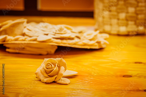 Beautiful rose shaped pastry on wooden table under soft lights with other pastry and background blurred slightly