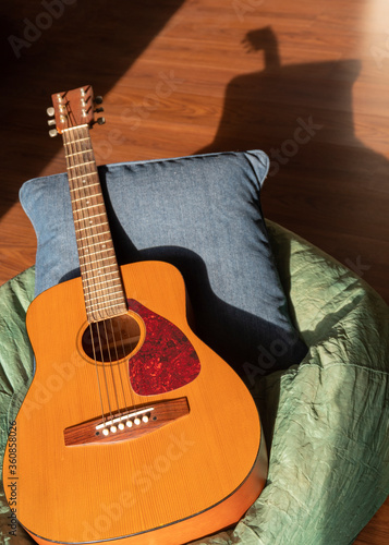 Acoustic guitar on bean bag with pillow