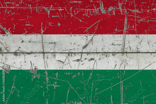Hungary flag painted on cracked dirty surface. National pattern on vintage style surface. Scratched and weathered concept. © sezerozger