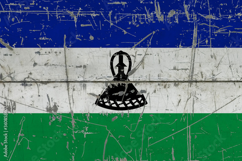 Lesotho flag painted on cracked dirty surface. National pattern on vintage style surface. Scratched and weathered concept. © sezerozger