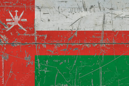 Oman flag painted on cracked dirty surface. National pattern on vintage style surface. Scratched and weathered concept. © sezerozger