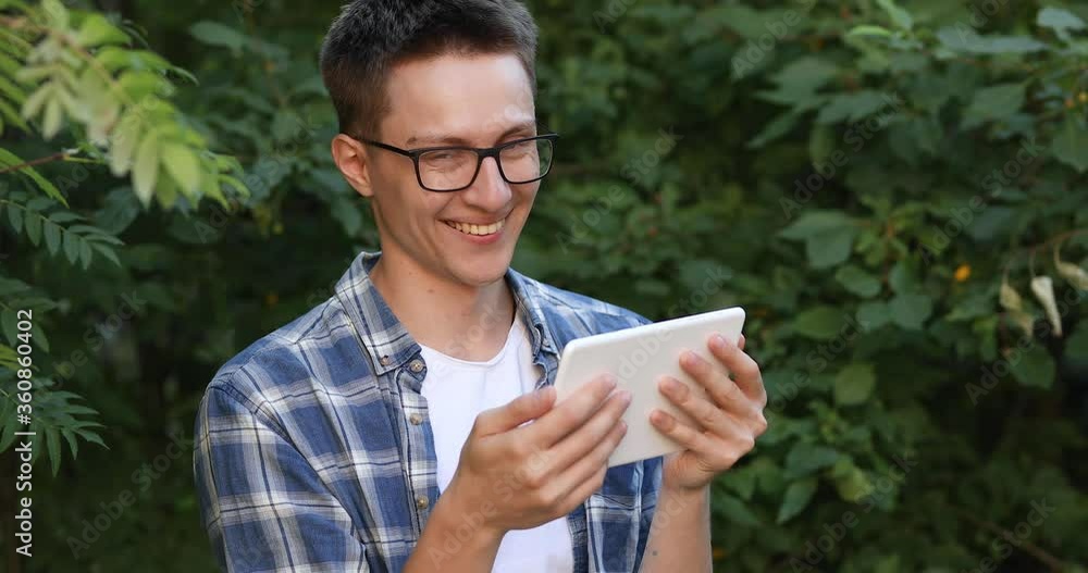 guy in a shirt, with a tablet in his hands on the street guy in a shirt, with a tablet in his hands on the street