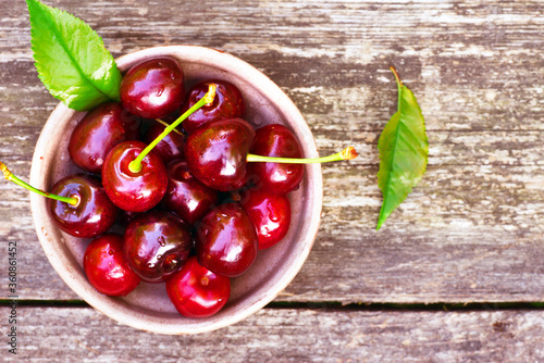 fresh cherries in a bowl, rustic grey background, top view