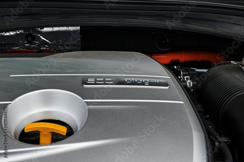 A look into the engine compartment of a plug-in hybrid car with various components.