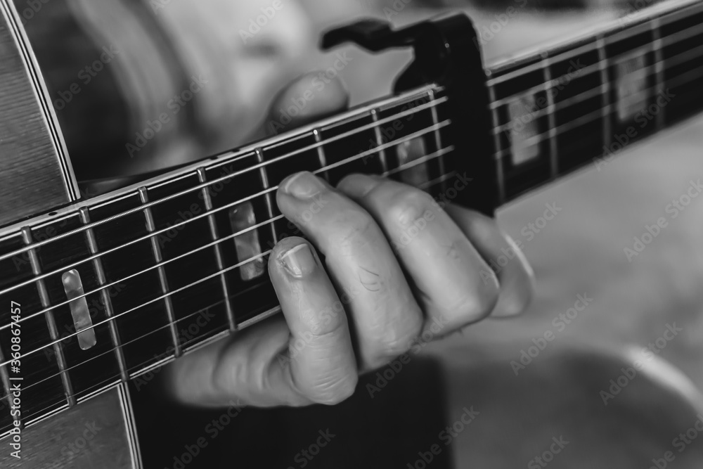 Fingers on guitar strings in black and white. Fingers on guitar strings in black and white.