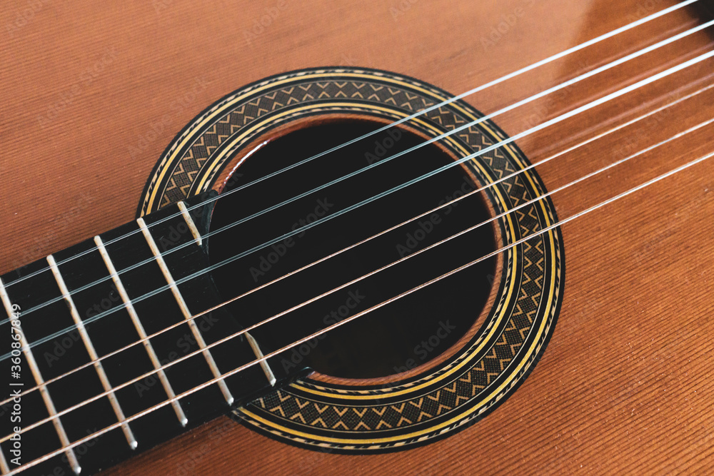 Obraz premium Vintage style photo of a classical guitar. Strings, sound hole, rosette and finger board.