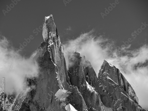 Grayscale shot of the Cerro Torre sharp mountain tops covered in snow on Argentina photo