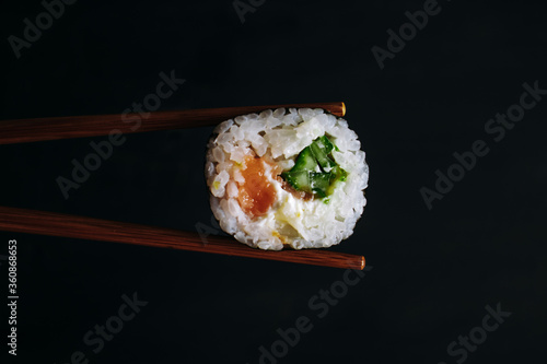  Roll with salmon and cucumber on a black background