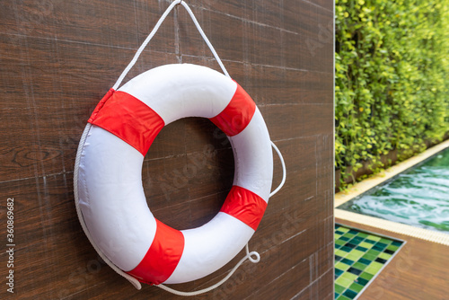 Safety torus or lifebuoy hanging on wooden wall at Swimming pool.Swimming is very popular sport in summer season