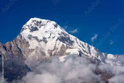 Annapurna South mountain peak with blue sky background in Nepal