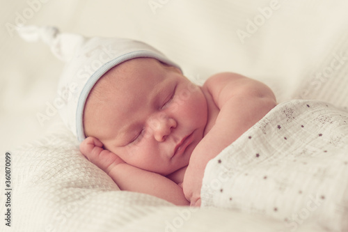 newborn baby sleeps in bed