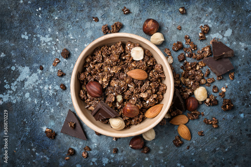 Oat flakes or granola with tasty chocolate and whole nuts for breakfast