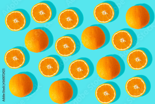 Orange oranges and cut oranges on turquoise background. Image of fresh oranges for the summer.