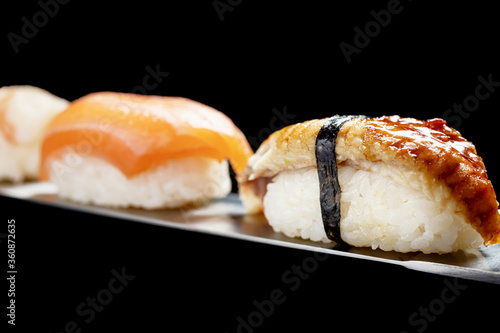 Wallpaper Mural Japanese rolls and seafood sushi on a katana sword on a black background Torontodigital.ca