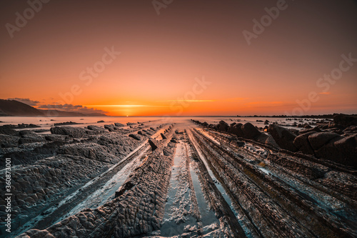 The incredible Flysch, a beautiful sunset in Sakoneta, is a beach in Deba. It is the western end of the Geopark of the Basque Coast, Guipuzkoa, Basque Country. The day ends with the sunset