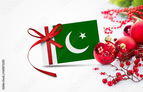 Pakistan flag on new year invitation card with red christmas ornaments concept. National happy new year composition.