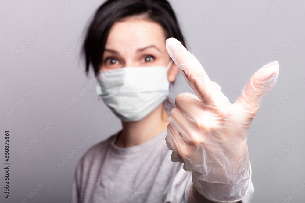 woman in gloves and medical mask, closeup portrait, gray studio background woman in gloves and medical mask, closeup portrait, gray studio background