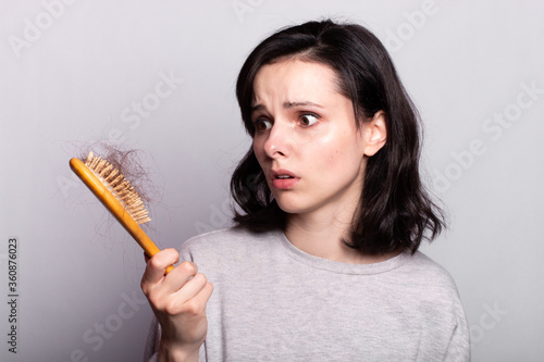 Beautiful woman comb hair grey shirt fall out