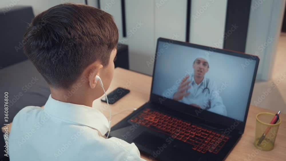 Rear view of boy online consultation with a pediatric doctor. Rear view of boy online consultation with a pediatric doctor.