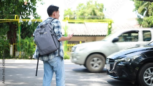 Asian man waiting for Uber taxi