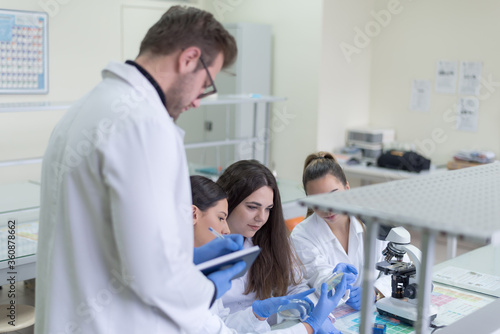 Group of Laboratory scientists working at lab with test tubes, test or research in clinical laboratory.Science, chemistry, biology, medicine and people concept.