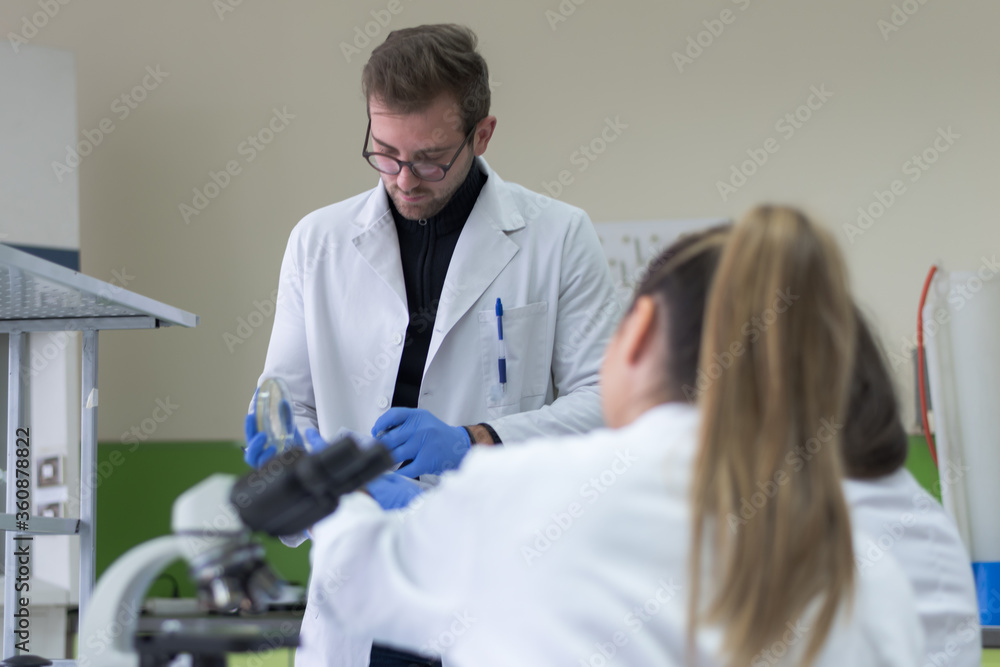 Group of Laboratory scientists working at lab with test tubes, test or research in clinical laboratory.Science, chemistry, biology, medicine and people concept. Group of Laboratory scientists working at lab with test tubes, test or research in clinical laboratory.Science, chemistry, biology, medicine and people concept.