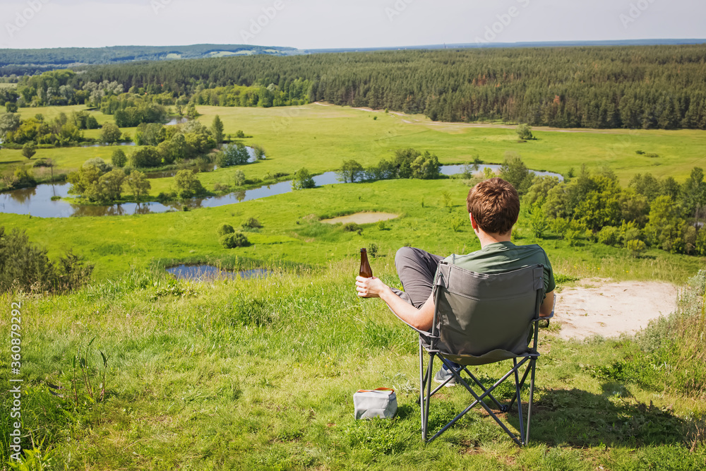 Man resting in a camping chair with beautiful view Man resting in a camping chair with beautiful view