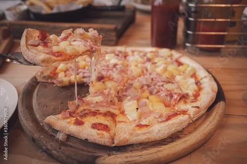 Hawaiian pizza on wooden board